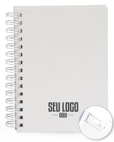 Foto de uma agenda diária para o ano de 2025, com capa marrom e uma espiral para folhear as páginas. Na imagem, é possível ver espaços em branco para escrever notas e lembretes, com um lápis e régua ao lado. A agenda está aberta em uma página em branco, pronta para ser preenchida com informações e compromissos.