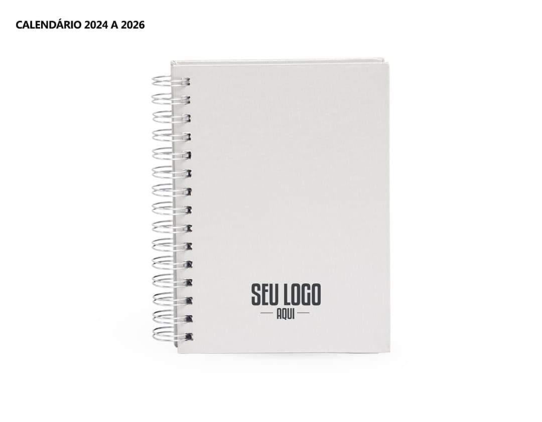 Foto de uma agenda diária para o ano de 2025, com capa marrom e uma espiral para folhear as páginas. Na imagem, é possível ver espaços em branco para escrever notas e lembretes, com um lápis e régua ao lado. A agenda está aberta em uma página em branco, pronta para ser preenchida com informações e compromissos.