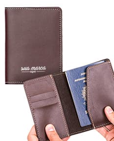 Porta passaporte em couro marrom, aberto com vários compartimentos para notas, cartão e dinheiro. Design moderno e elegante, ideal para viagens e organização de documentos.