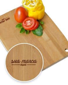 Tábua de corte de madeira com acesso a gancho, com legumes frescos como tomate, pimentão, cebola, alho, abóbora, alface, salsa e pepino. Ingredientes saudáveis e coloridos dispostos em cima da tábua, prontos para serem preparados em uma refeição gourmet e saudável.