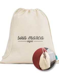 Sacola mochila de algodão orgânico 120 g, vazia e em um tom de amarelo suave. A imagem mostra a sacola aberta, com um design vintage e textura grunge. Ao redor dela, há um envelope, notas de dinheiro, uma página em branco, um livro antigo e um cartão. O cenário remete a uma atmosfera retro e nostálgica, ideal para representar um presente especial.