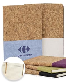 Caixa de papelão vazia de cor marrom, utilizada para embalagem e transporte de objetos. A imagem mostra várias caixas empilhadas dentro de uma sala, com um sofá ao fundo e uma caderneta em cortiça sobre uma delas.