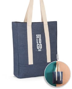 Sacola de denim reciclado com bolso, em tons de marrom e amarelo. Possui alça em couro, fecho com cadeado e etiqueta de preço. Ideal para compras e presente, demonstrando elegância e versatilidade.
