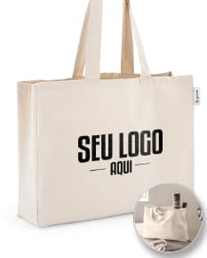 imagem de uma sacola de algodão reciclado 220g/m², com design moderno e elegante, na cor preta e prateada. O objeto está vazio, apresentando um acabamento em couro e um fecho de zíper. A embalagem é transparente e possui alças para transporte. Ideal para compras e como acessório pessoal.