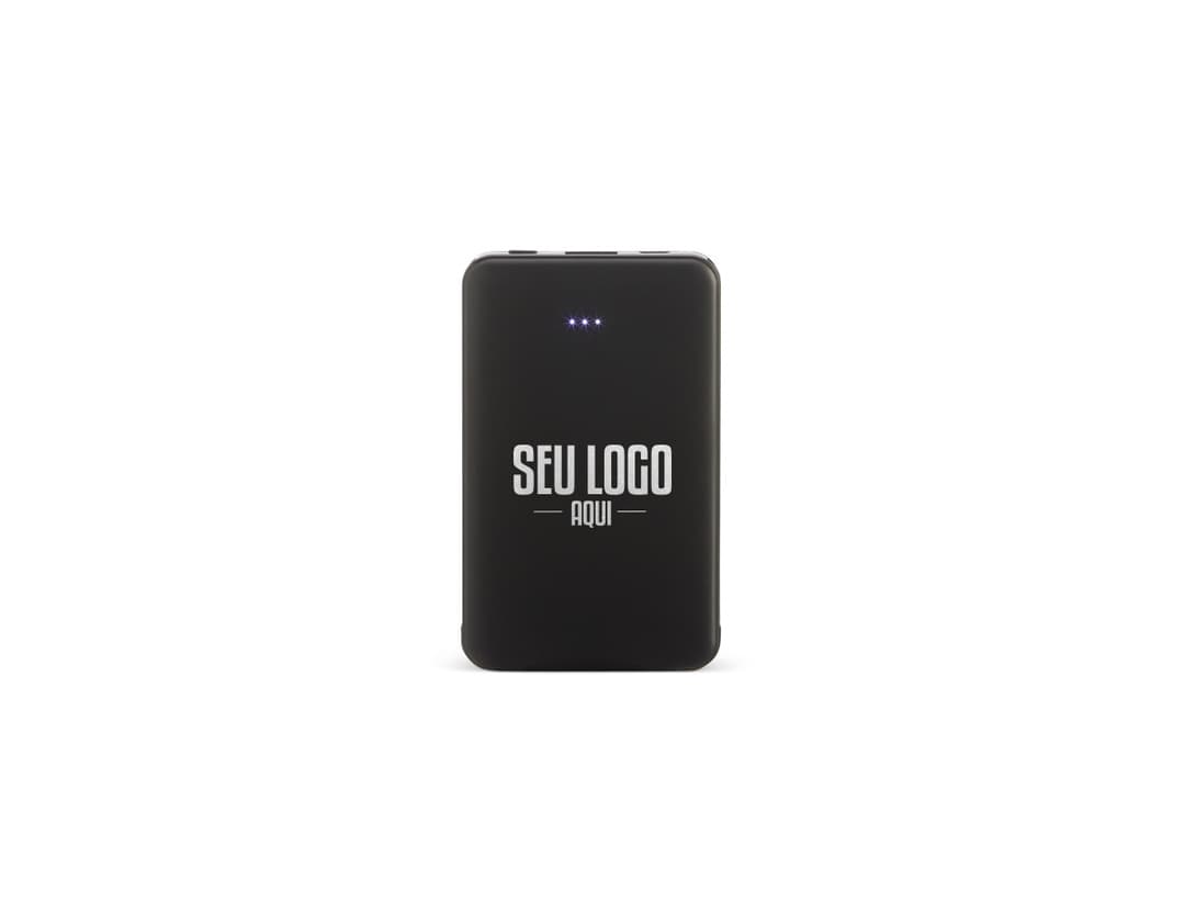 Power Bank Plástico 5.000mAh preto, dispositivo de tecnologia com adaptador e cabo de conexão. Equipamento eletrônico moderno para carregar dispositivos móveis. Visto contra um fundo de papel e teclado de computador.
