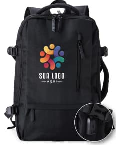 Homem de negócios usando um elegante terno preto, segurando uma mochila de nylon preta de 20 litros com USB. O acessório tem apoio nas costas, alça, e suporte para objetos.