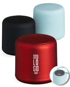 Caixa de som Bluetooth preta e prateada, com design moderno e compacto. Feita de material metálico e plástico, possui botões de controle, entrada USB e conexão sem fio. Ideal para uso em escritórios, em casa ou em ambientes corporativos.
