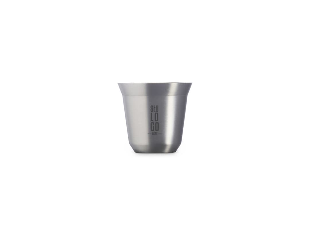 Copo de Inox de 100ml em uma mesa, ao lado de uma xícara de chá e diversos utensílios de cozinha. O copo está vazio, limpo e brilhante, com um design elegante.
