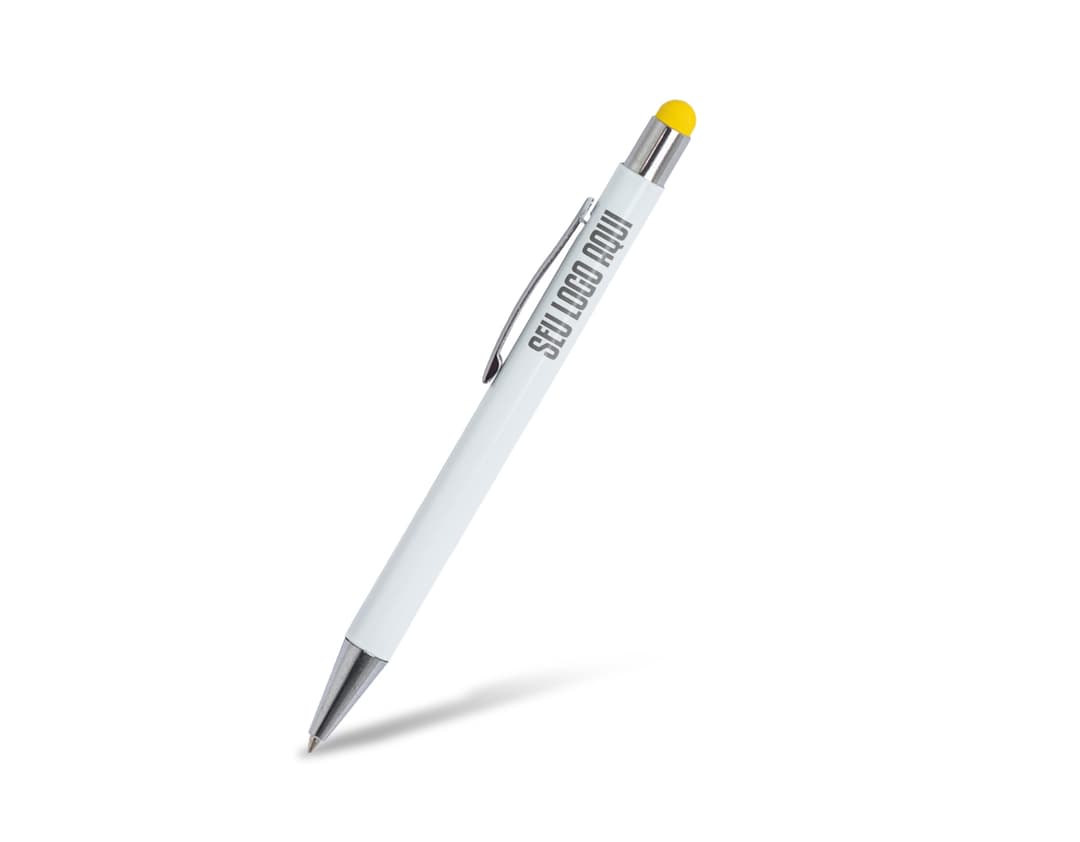 Caneta Metal Touch prateada sobre uma mesa de escritório, ao lado de um caderno, uma secretária e um lápis.