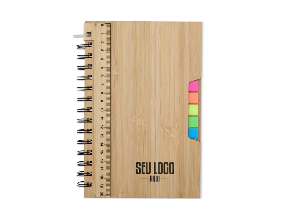 Caderno A5 Bambu em textura de bambu, aberto e com páginas em branco. Possui régua de medição, instrumento de medição, notebook, papel, anotações, espaço para escrever e design clean. Ideal para estudo, trabalho ou projetos.