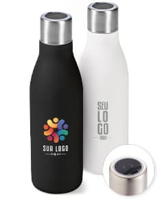 Garrafa em aço inox contendo bebida alcoólica, com tampa de cortiça. A garrafa está vazia e possui rótulo em branco. Está em pé sobre uma superfície de vidro, com reflexo no fundo escuro. A imagem é vertical e destaca a elegância e luxo do produto.