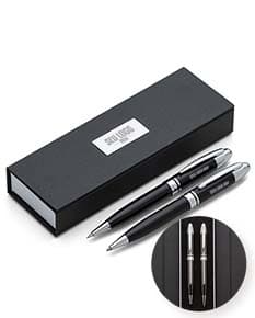 Conjunto de caneta e lapiseira metal em tom prateado, com detalhes em preto e clip para prender no bolso.