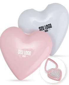 Escova com espelho em um cabo de plástico na cor rosa. O espelho está preso na parte de trás da escova.