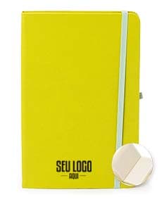 Caderneta de couro sintético vazia em um escritório amarelo, com espaço para inserir notas e documentos.