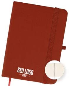 Caderneta emborrachada preta com design vintage, vazia e com textura grunge. Aparecem um notebook, um metrônomo, uma guitarra, uma página em branco e um pendulo.