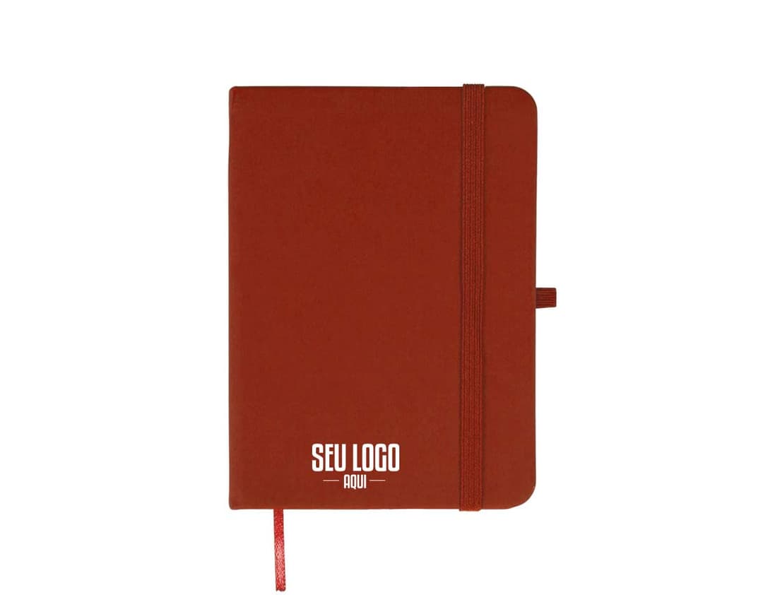 Caderneta emborrachada preta com design vintage, vazia e com textura grunge. Aparecem um notebook, um metrônomo, uma guitarra, uma página em branco e um pendulo.