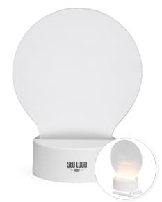 Luminária LED de mesa na cor branca, com braço flexível e base redonda.