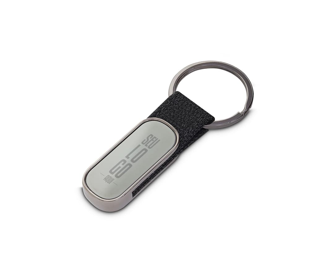 Chaveiro de metal moderno e elegante em formato de telefone celular, com tela digital e teclado. O dispositivo possui botões de comunicação e é feito de couro, na cor preta e prata.