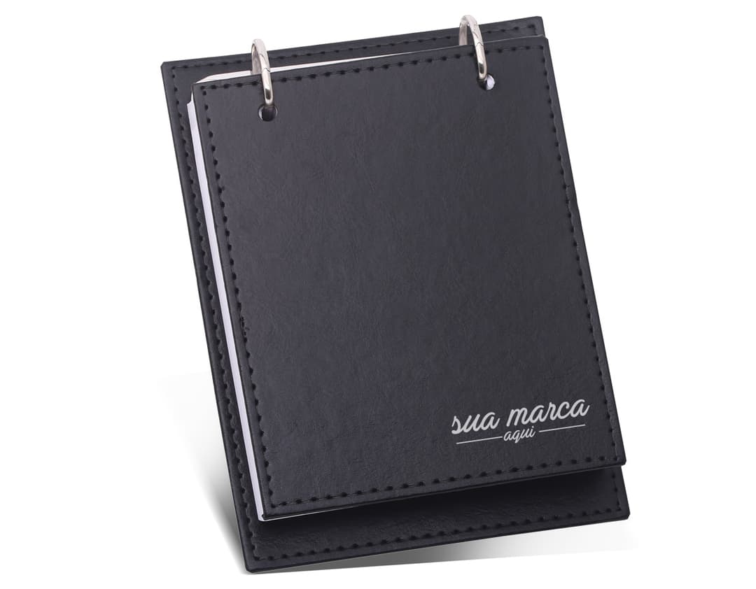 Bloco de Anotações Couro - 01: ideal para organizar suas ideias e tarefas com estilo. Feito em couro legítimo, possui espaços para documentos e caneta. Perfeito para reuniões de negócios ou anotações do dia a dia. Adquira já o seu!